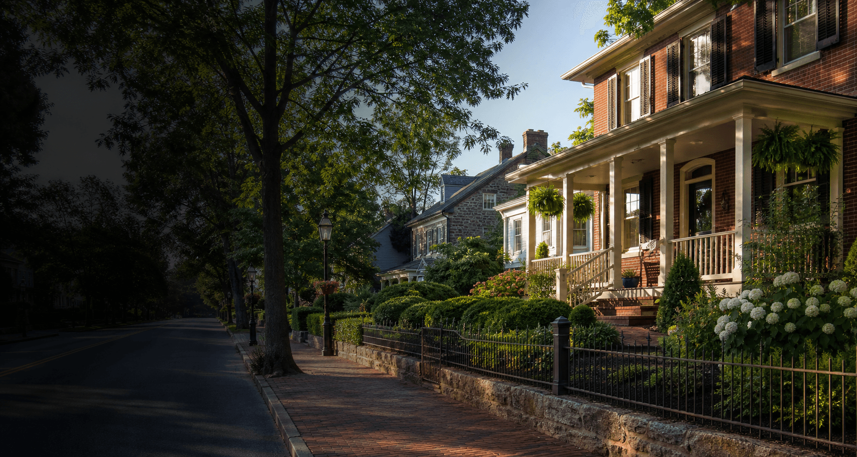A historic, tree-lined Frederick, Maryland streetscape at golden hour